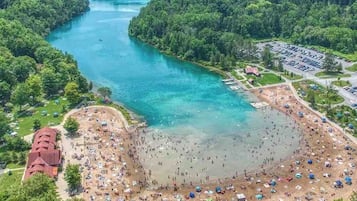 Une zone de plage bordée d’une rivière, le tout entouré d’une végétation luxuriante.