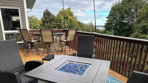 An outdoor patio with a square table, wicker chairs, and a fire feature. - Open layout with views, jacuzzi tub (Syracuse)