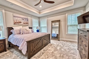 A bedroom with a bed, a dresser, a mirror, and a ceiling fan. - Coastal Club Resort House in Lewes: Coastal Elegance Awaits (Lewes)