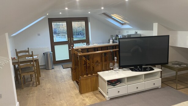 Un loft moderno con comedor, televisión y una zona de estar acogedora.