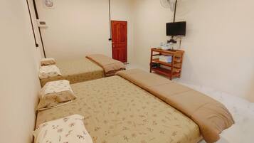 A room with two beds, a wooden nightstand, a TV, and a door.