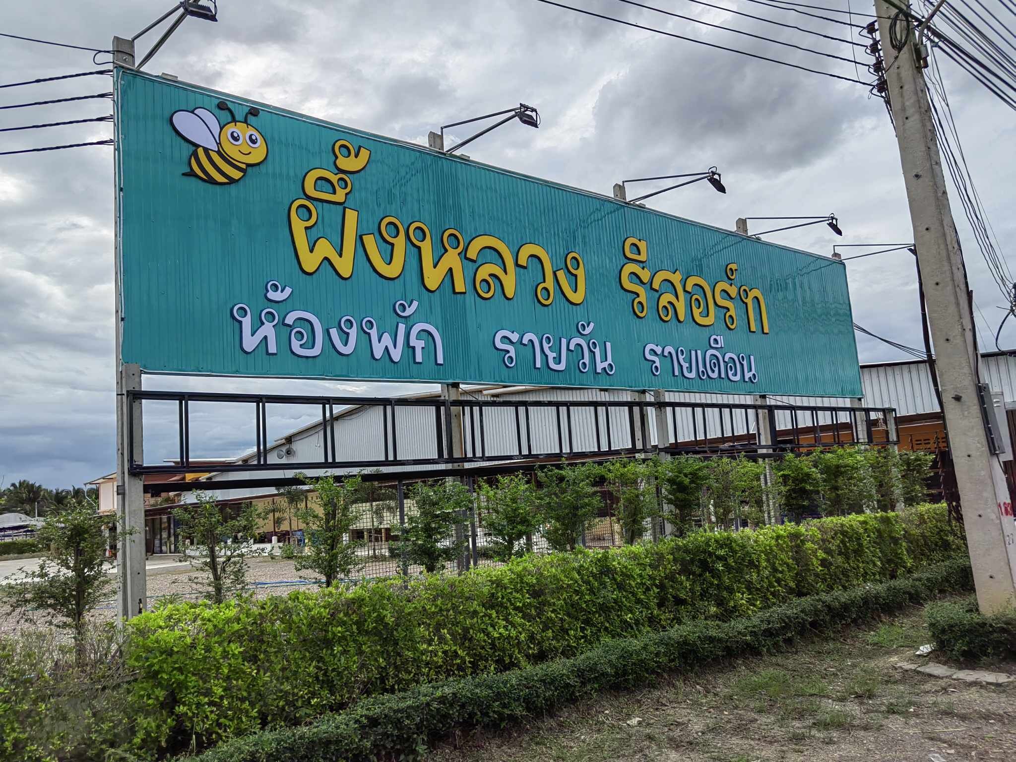A large billboard with text and a bee graphic.