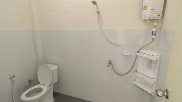 Un baño con inodoro, ducha y calentador de agua.