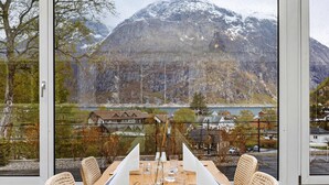 A dining table set with chairs, a mountain view, and a lake. - Eidfjord Hotel (Eidfjord)