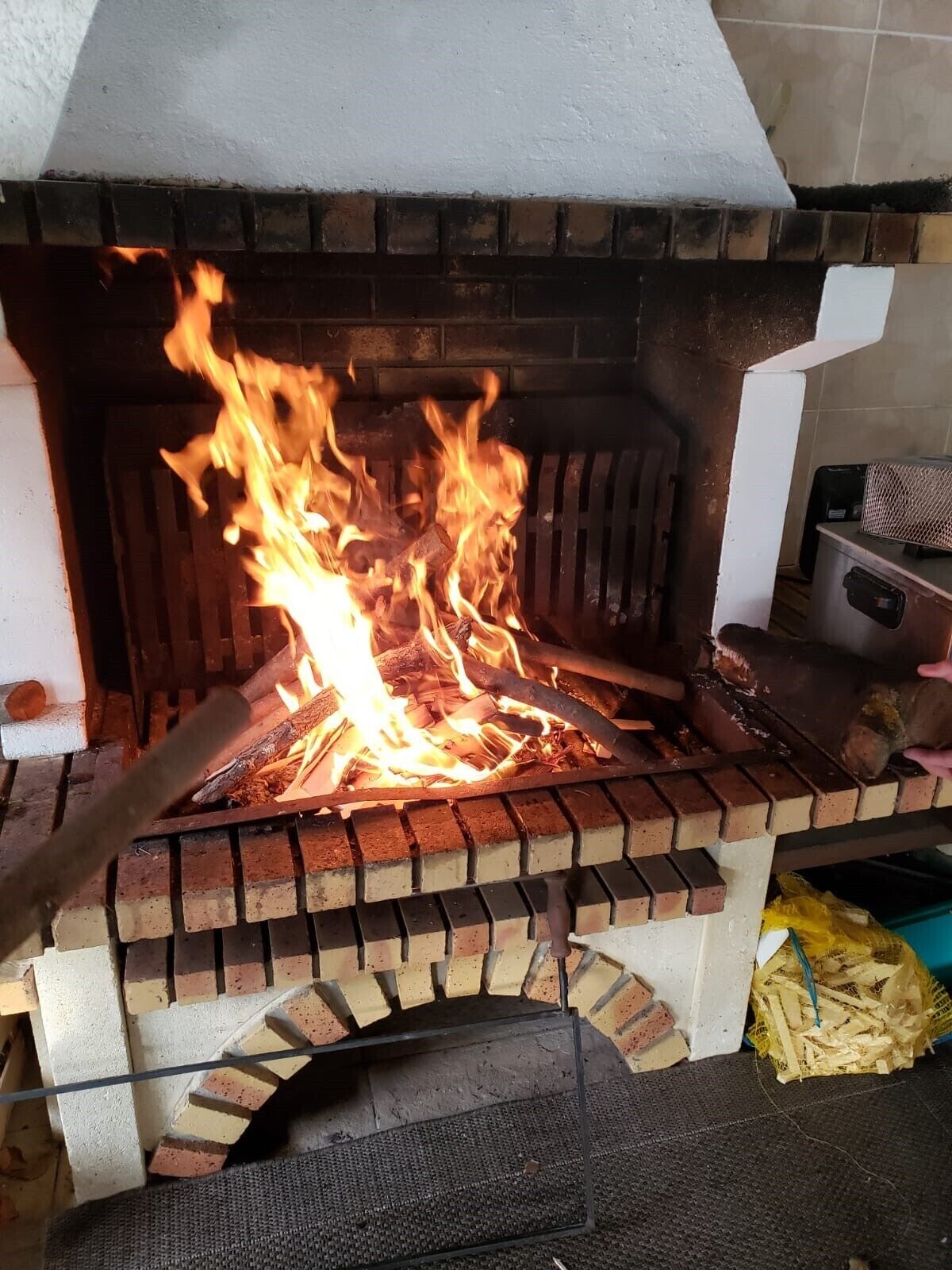 Ein Backofen aus Ziegelsteinen mit brennendem Feuer darin.