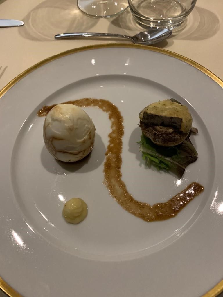 A plate with a dessert, a main dish, and a sauce.