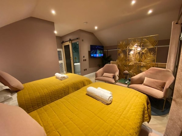 A hotel room with two beds, a TV, a small table, and a chair. - Ailim House Serviced Cottage (St. Andrews)