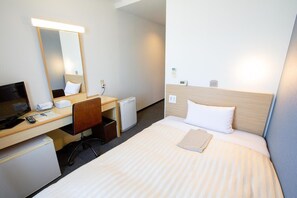 A hotel room with a bed, a desk with a computer, a chair, a small desk lamp, and a bedside table. - Super Hotel Matsuyama (Matsuyama)