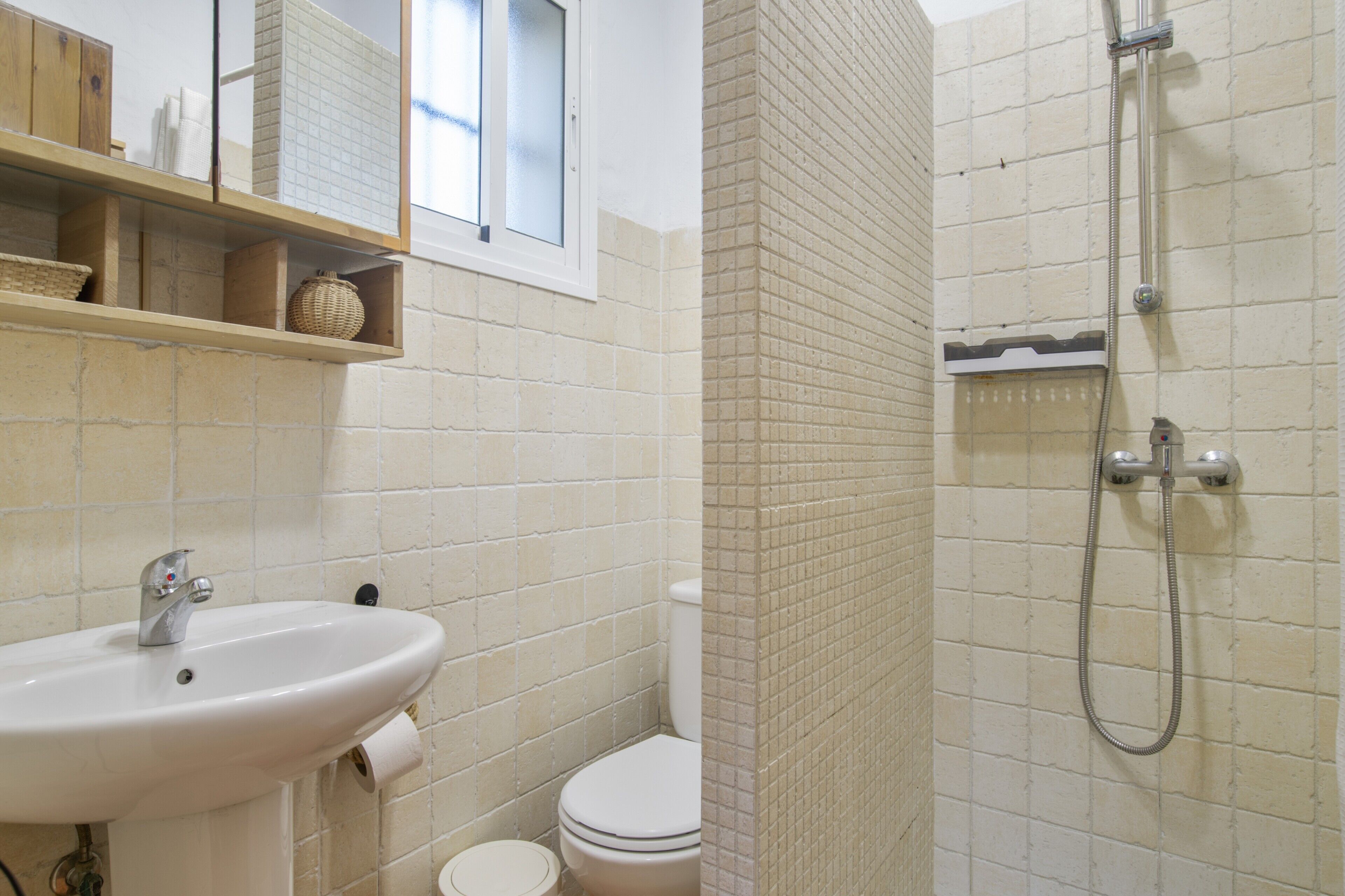 Un baño con lavamanos, inodoro y ducha.