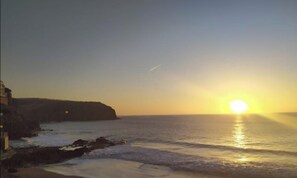 A sunset over a coastal area with a cliff and ocean. - Vacation Apartment 'El Refugio' (Puerto de Sardina)