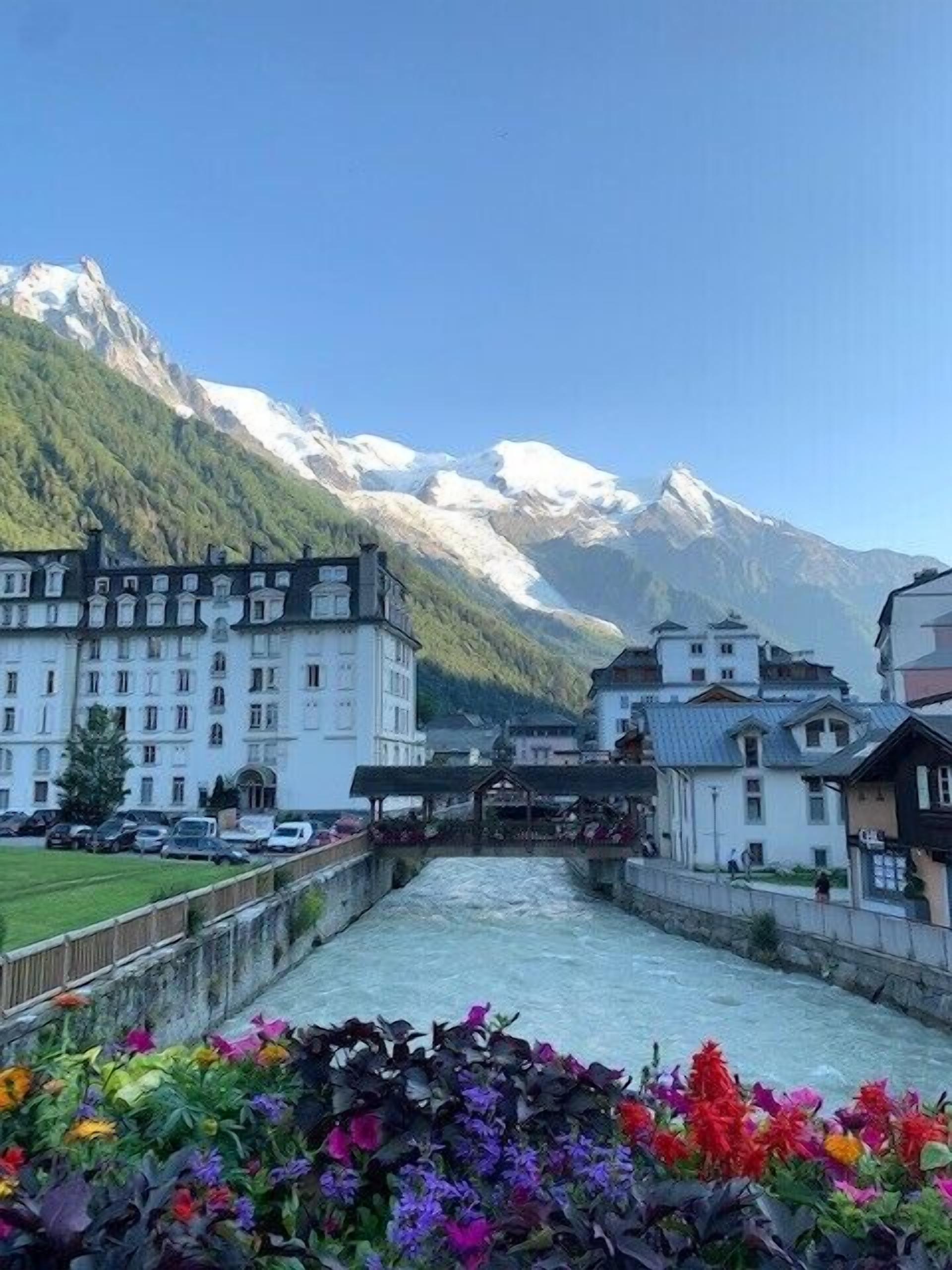 Ein Hotel am Flussufer mit Blick auf schneebedeckte Berge.
