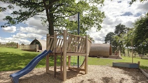 A playground with a slide, climbing structure, and a fenced area.