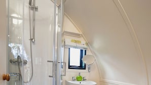A bathroom with a glass-enclosed shower, a pedestal sink, and a toilet.