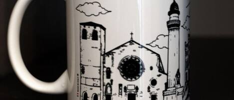 A white mug with a black illustration of a church and the word "TRIESTE" on it.