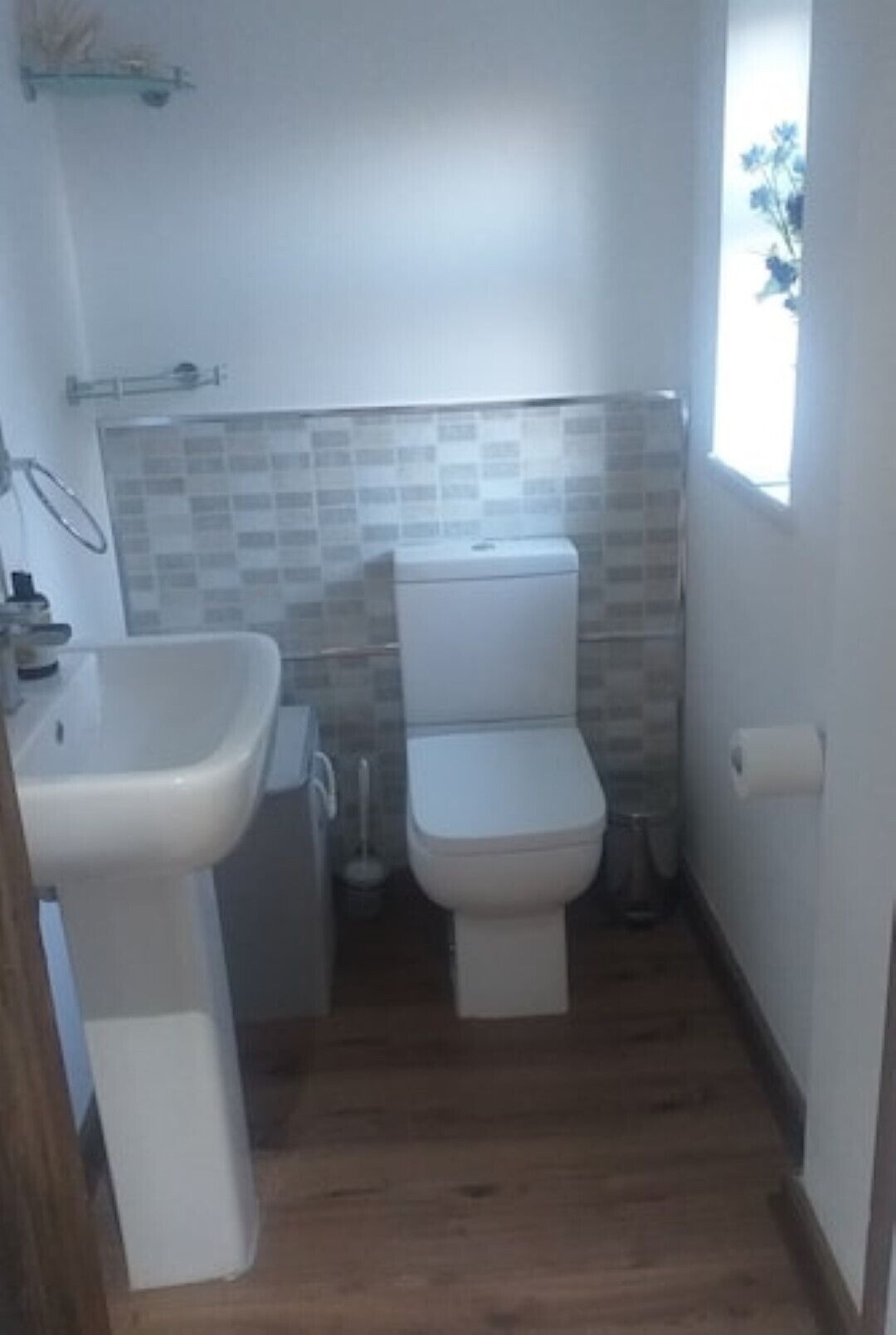 Un bany petit amb vàter, rentapel i finestra.