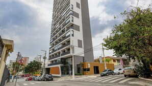 A tall, modern apartment building with multiple balconies and a flat facade. - SB Setin Brooklyn Studios (São Paulo)
