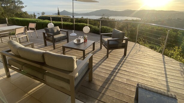 A deck with outdoor furniture, including a sofa and chairs, and a table with a tray and bottles. - Villa for 10 people - swimming pool - 180° panoramic view - 5 air-conditioned bedrooms   (Saint-Raphaël)