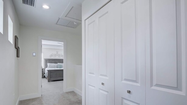 A hallway with a bed, a wardrobe, and a door. - Trendy Naples Retreat: Modern Vacation Home (Naples)