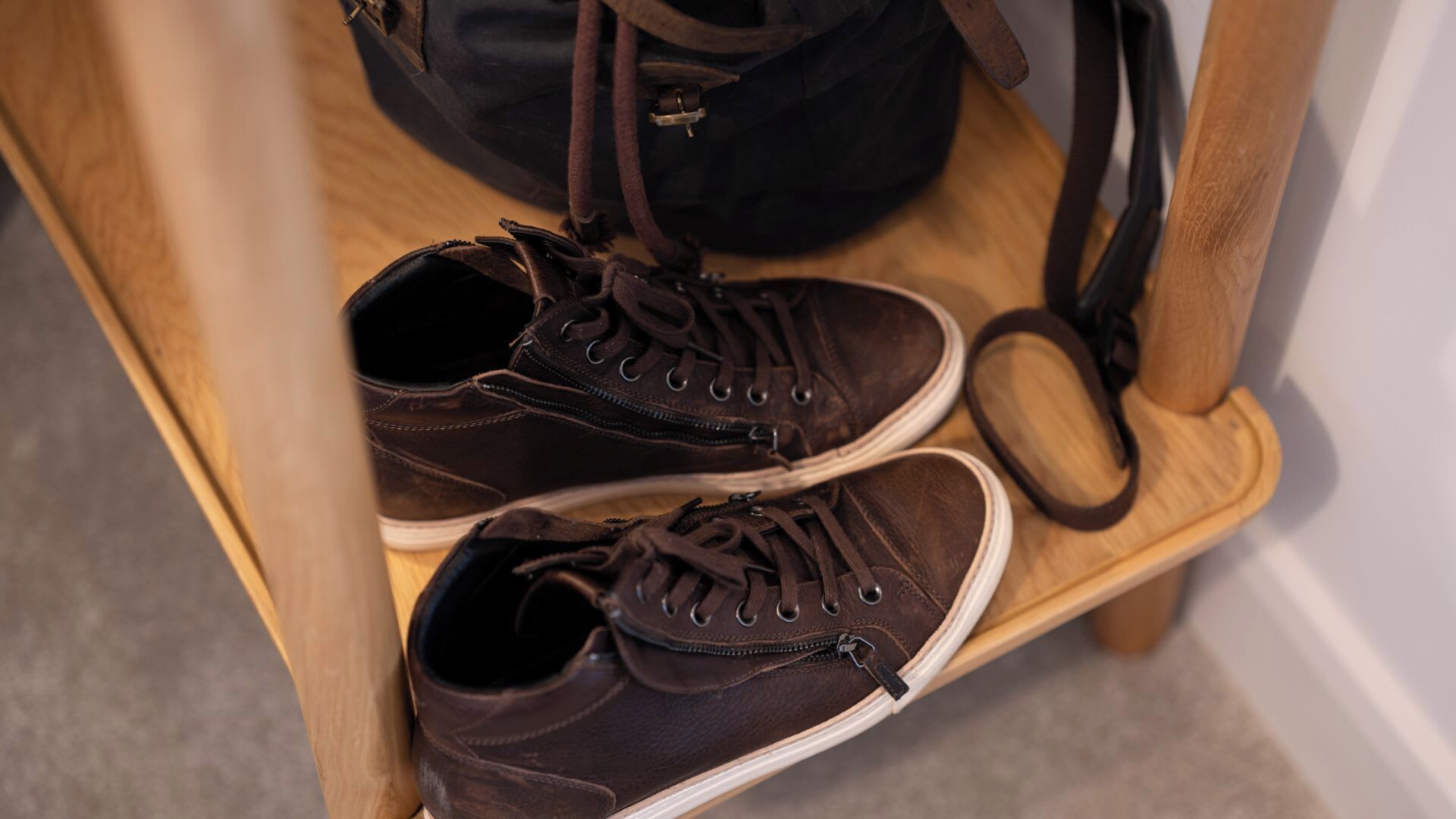 Ein Paar braune Schuhe auf einer hölzernen Bank.