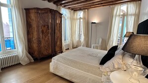 A bedroom with a wooden ceiling, a large bed, a wardrobe, and a bedside table with a lamp. - "BIGHOUSE" VENICE CENTER NEW AND LUXURY FLAT (Venezia)