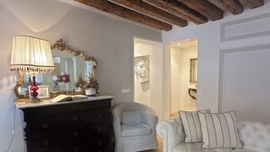 A living room with a wooden ceiling, a black dresser, a white sofa, and a red lamp. - "BIGHOUSE" VENICE CENTER NEW AND LUXURY FLAT (Venezia)