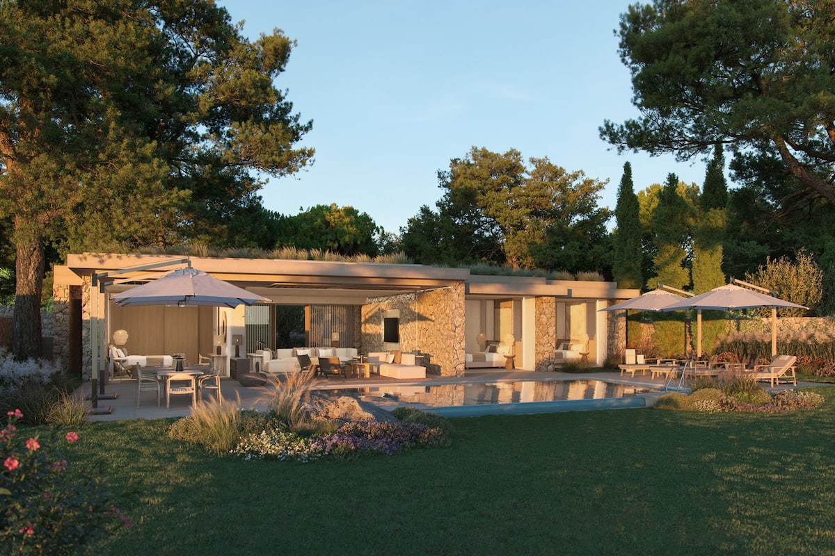 A modern house with a pool, outdoor seating, and a stone facade.