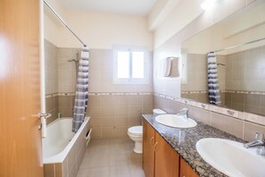 Een bad/douchecombinatie, handdoeken