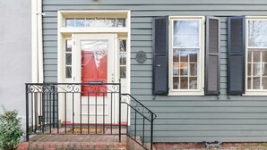A house with a red door, a brick entrance, and a black metal railing. - Historic, Charming Home in Old Town (Alexandria)