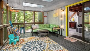 A modern living room with a green sofa, a coffee table, and a blue Adirondack chair. - Eclectic Family Poconos Escape! Skiing 5min away! Firepit, Near Woodloch/winery! (Lackawaxen)