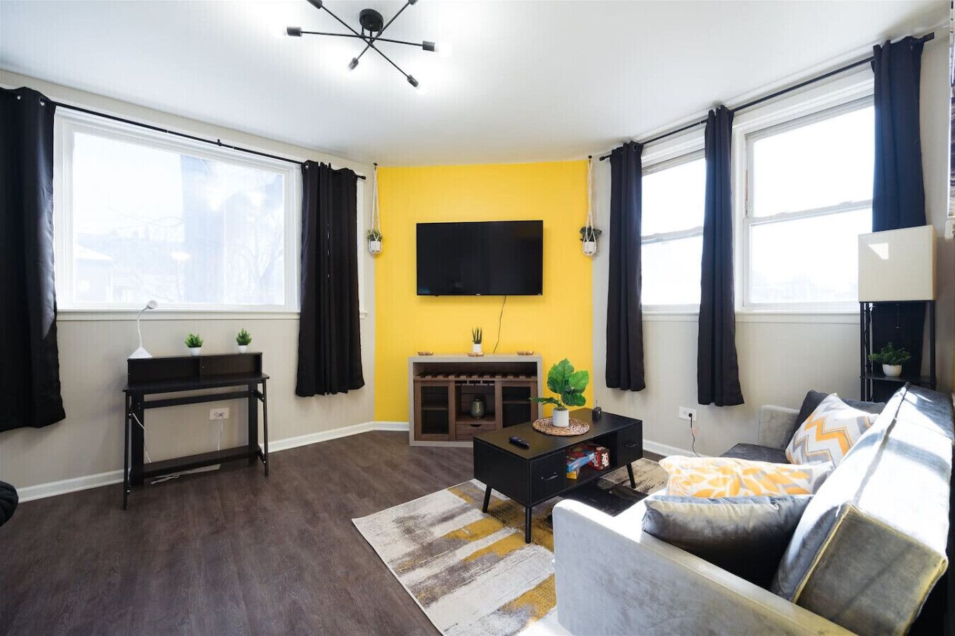 A living room with a sofa, a coffee table, a TV, and a plant.
