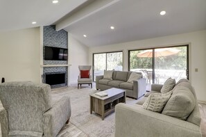 Ein Wohnzimmer mit Kamin, einer Couch, einem Sessel und einem Couchtisch.