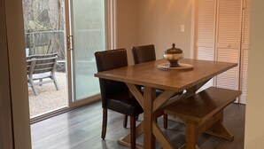 A dining area with a wooden table, chairs, and a chandelier.