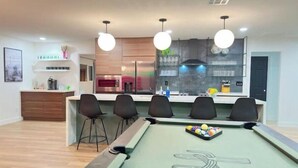 A modern kitchen with a built-in pool table, bar stools, and pendant lighting. - The Hugging Cactus. Old Town's Finest.  (Scottsdale)