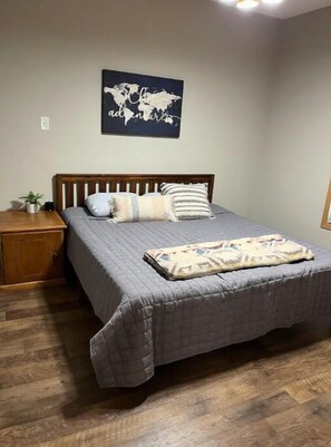 Cozy retreat with a single bed, world map artwork, and a potted plant.