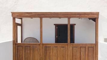 Une structure en bois dotée d’une porte et d’une moustiquaire, qui pourrait être une pièce ou un espace de rangement.