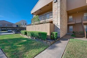 Stunning two-story residence with a balcony and beautifully manicured lawn.