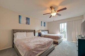 Two single beds with headboards and bedside tables, a dresser, and a mirror.