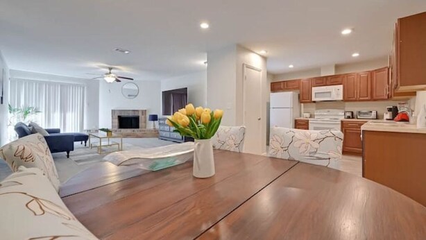 A modern living room with a wooden dining table, a sofa, and a fireplace.