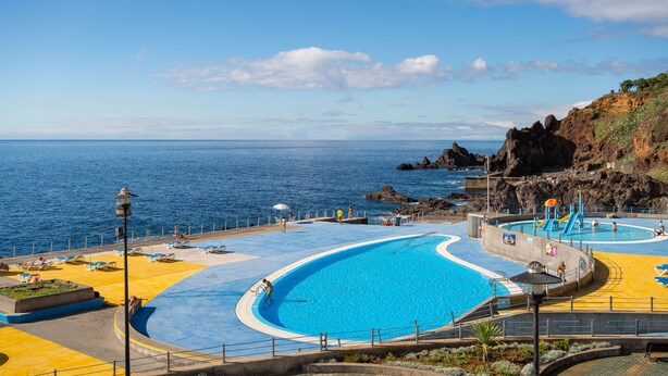 A coastal swimming pool with clear blue water, surrounded by a rocky landscape and a view of the sea. - Premium quiet apt, Funchal seafront | Oceanbreeze (Funchal)