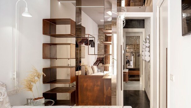 Un dormitorio moderno con una cama grande, un armario de madera y un escritorio empotrado.