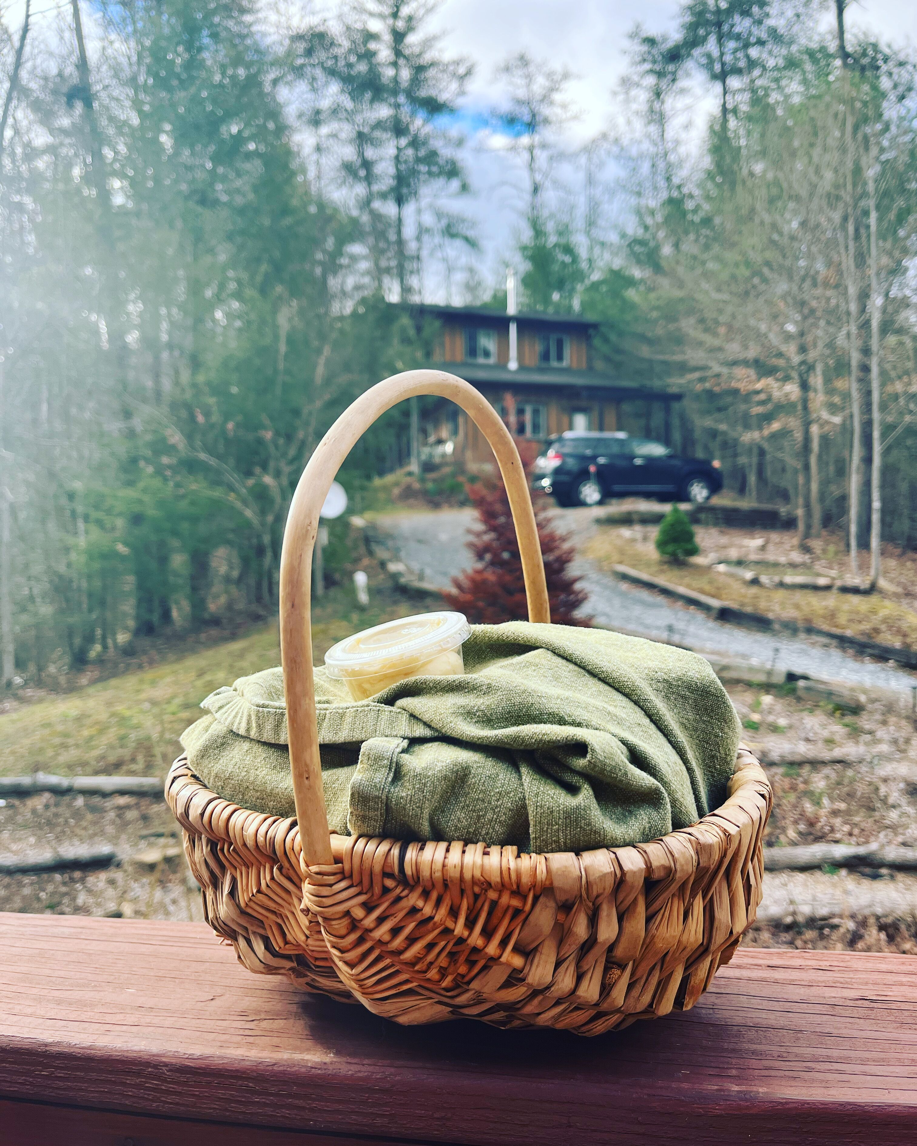 A wicker basket with a handle on a wooden surface.