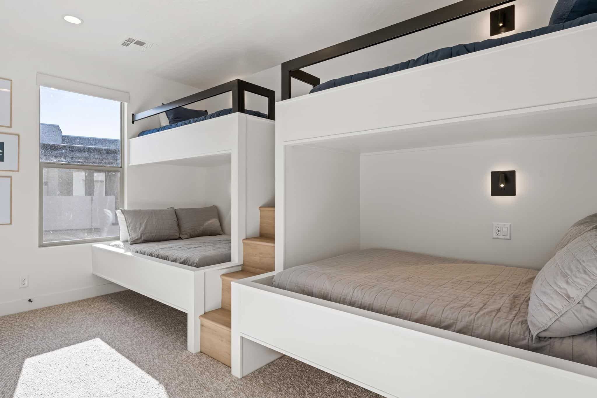 Una camera da letto moderna con letti a castello, sedute integrate e una finestra vista.