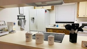 A kitchen with a coffee maker, a kettle, and a tea kettle on the counter. - Lovely 1 bedroom unit with pool (Sebring)