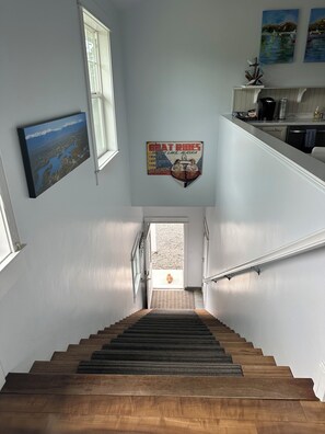 A wooden staircase leading to a landing with a view of a gravel area. - Lakeside three bedroom boathouse. (Wasilla)