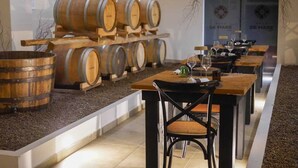 A restaurant with wooden barrels and a long dining table. - DE MARE WINE RESORT (Ciro Marina)