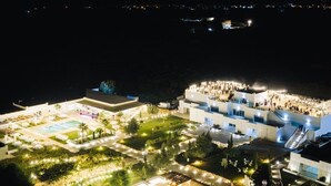 A large, well-lit hotel complex with multiple buildings and a swimming pool area. - DE MARE WINE RESORT (Ciro Marina)
