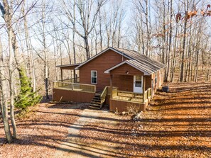A small cabin with a porch and a staircase leading to the entrance.