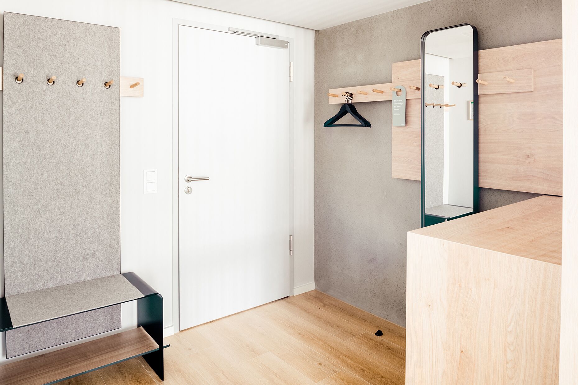 Ein modernes Badezimmer mit einem Holzbadezimmerhocker, einem Spiegel und einem Handtuchhalter.