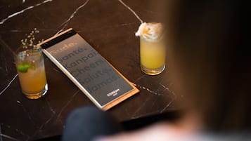 Ein Tablet zeigt eine Nachricht, zwei Getränke auf einem Marmortisch.