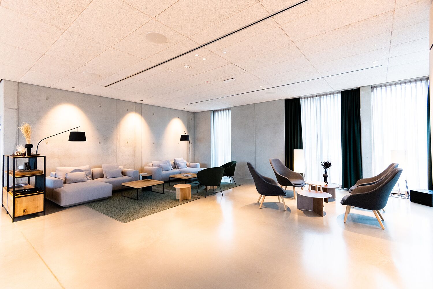 Un salon moderne comprenant un canapé, des fauteuils, une table basse et une bibliothèque.